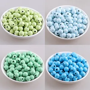 Dettaglio di perle tonde in legno colorate in quattro tonalità tenui macaron