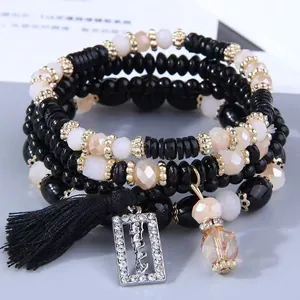Set di braccialetti di perline multistrato bohémien con ciondolo happy e nappa nera chic.