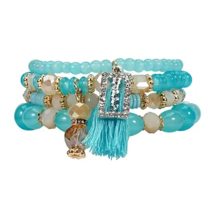 Dettaglio di set di braccialetti di perline multistrato con nappa e ciondolo happy