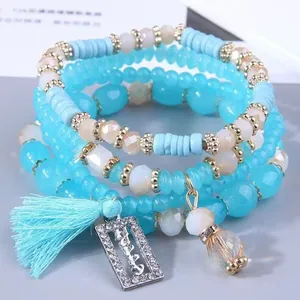 Vista dettagliata del bracciale di perline blu a quattro strati con ciondolo "happy".