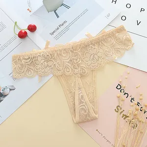 Close-up detail of beige floral lace thong with delicate ribbon accents