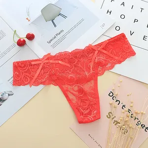 Detail view of red floral lace thong with delicate bow accents on a stylish flat lay