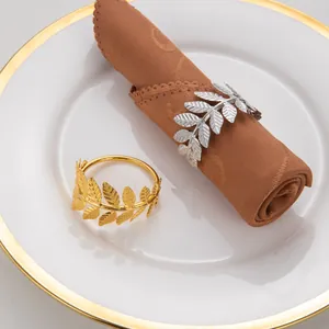 Gros plan de ronds de serviette en forme de feuille d'or et d'argent sur assiette