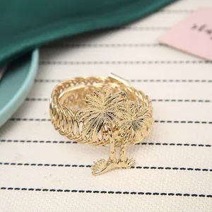 Detailed macro view of an elegant gold metal napkin ring featuring a palm tree design