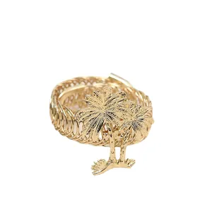 Detailed macro view of golden metal napkin ring featuring a tropical palm tree design