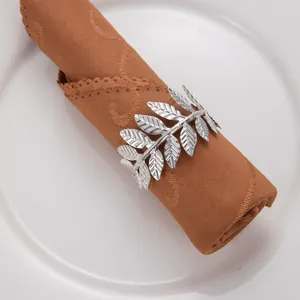 Détail rapproché d'un rond de serviette argenté en forme de feuille élégante