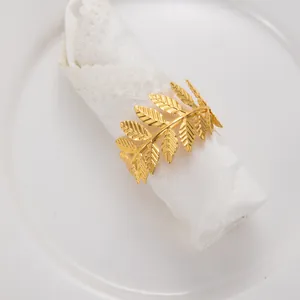 Vue détaillée du motif de feuilles dorées sur une boucle de rond de serviette métal