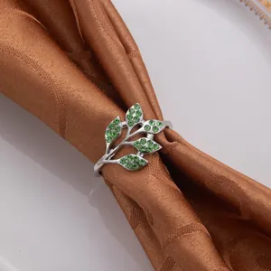 Exquisite Nahaufnahme eines silbernen Serviettenrings mit grünen Blättern und Strasssteinen