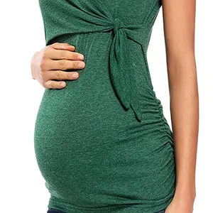 Detail shot of a green maternity top featuring ruched sides and a front knot design