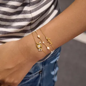 Detail view of 18K gold plated stackable bracelets with zircon evil eye and Lucky motifs