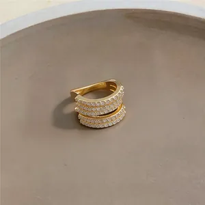 Primo piano di un ear cuff dorato a più strati con zirconi bianchi scintillanti