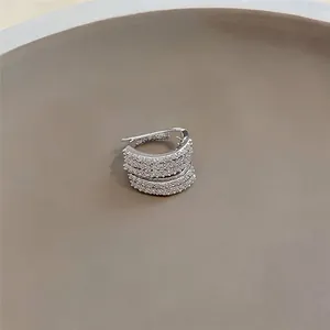 Dettaglio di un elegante ear cuff multistrato in argento e zirconi per orecchie non forate