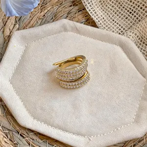 Dettaglio di un lussuoso ear cuff multistrato in tonalità oro con zirconi pavé.