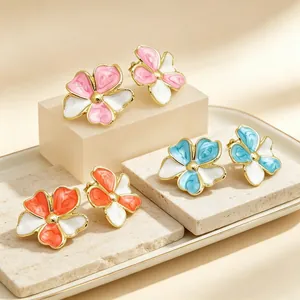 Detail von drei Retro-Emaille-Blumenohrsteckern in den Farben Pink, Blau und Orange.