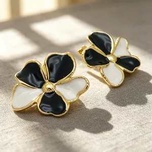 Detaillierte Nahaufnahme der Vintage-Emaille-Ohrringe mit schwarz-weißen Blumenmotiven