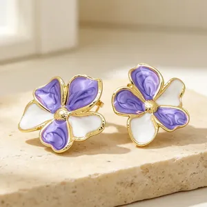 Detaillierte Makroansicht eleganter lila-weißer Emaille-Blumenohrstecker mit Gold-Finish