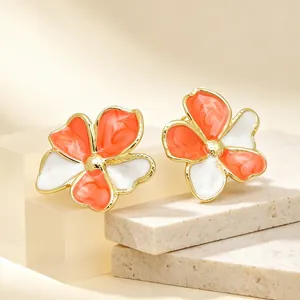 Detailansicht der orange-weißen Emaille-Blumenohrstecker aus goldfarbenem Titanstahl