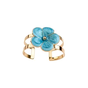 Elegant gold-tone cuff bracelet featuring a vibrant blue enamel flower resort style design.