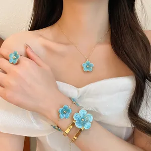 Close-up view of a tropical style blue enamel flower necklace, ring and bracelet set
