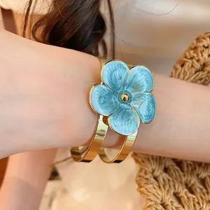 Elegant blue enamel flower cuff bracelet with a polished gold finish for resort style