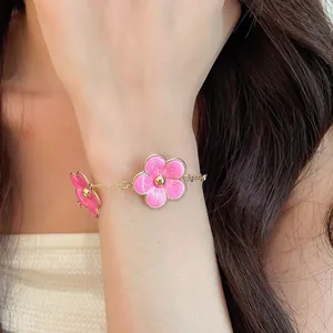 Detailed view of an elegant pink enamel flower bracelet worn on a female wrist