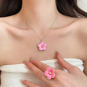 Close-up of elegant pink flower pendant necklace and matching ring on Asian model