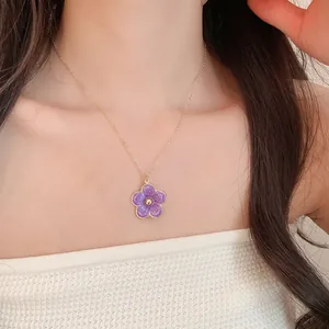 Detailed close-up shot of an elegant purple flower pendant necklace on a model's neck