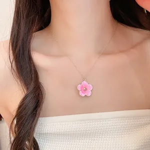 Pink enamel flower pendant necklace worn by a model in island resort style fashion