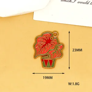 Vue détaillée d'une breloque plante en émail rouge et vert avec dimensions 23x19 mm