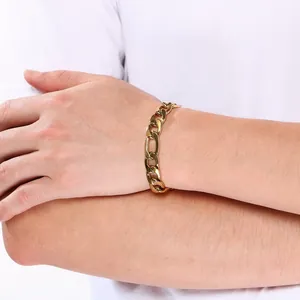Gros plan d'un bracelet en chaîne Figaro en acier inoxydable doré porté au poignet