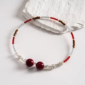 Macro view of vintage beaded choker with red acrylic stones and silver flower accents