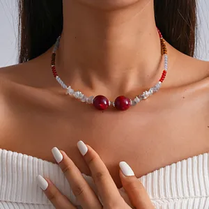 Close-up detail of vintage beaded choker featuring red marbled beads and silver floral accents