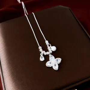 Elegant silver-colored clover flower pendant necklace with zircon and pearl accents.