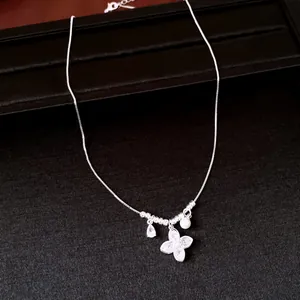 Detailed shot of silver necklace with zircon flower pendant and pearl accent