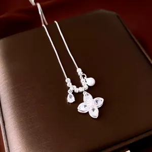 Elegant silver necklace detail showing zircon-studded flower pendant with pearl accent