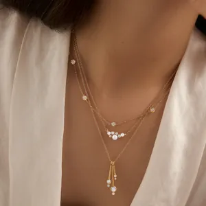 Elegant layered gold titanium steel necklaces with pearl and crystal pendants on model