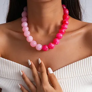 Primer plano de un collar de cuentas de acrílico veteado en rosa degradado usado por una modelo