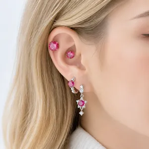 Elegante rosarote Stern-Ohrhänger und Titanstahl-Ohrknorpelstecker an einer Frau