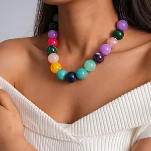 Vista detallada de un colorido collar de cuentas de acrílico jaspeado en una modelo