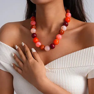 Primer plano de un collar de cuentas de acrílico veteado vibrante en el cuello de una modelo
