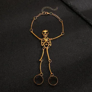 Detailed view of gothic punk gold skull hand chain with rings displayed on black background