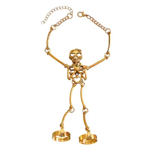Detailed macro view of a gothic gold skeleton hand bracelet featuring a skull and rings