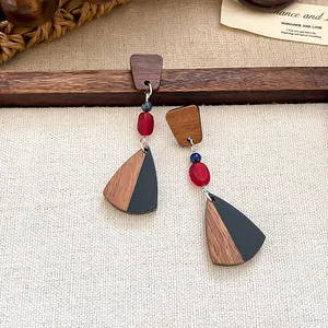 Detailansicht der Retro-Ohrringe aus Holz und schwarzem Harz mit roten Perlen