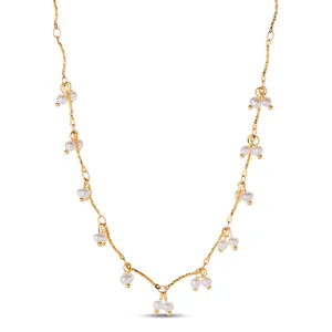 Detailed macro view of elegant gold stainless steel chain with dangling white pearls.