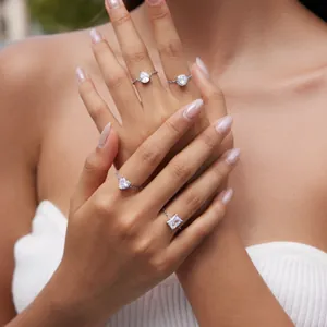 Detailed view of four adjustable zircon rings with different stone cuts on a hand