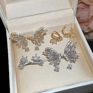 Detail view of 18k gold plated butterfly and star zircon ear clips in a jewelry box