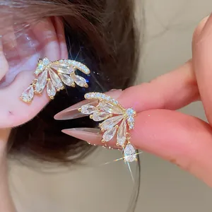 Macro detail of 18k gold plated butterfly ear cuffs with sparkling cubic zirconia crystals