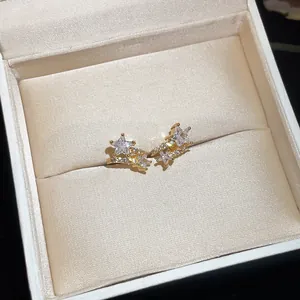 Close-up detail of 18k gold plated star ear clips with sparkling cubic zirconia stones