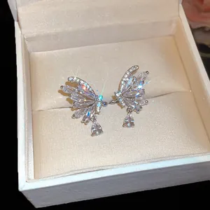 Detailed close-up of butterfly wing ear clips featuring sparkling zircons and waterdrop charms