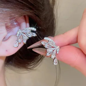 Close-up of elegant zircon butterfly ear cuffs with water drop dangles in silver finish